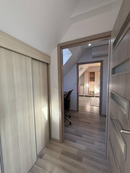 A hallway with a built-in wardrobe and a floor with a wooden decor in a 4-room apartment.