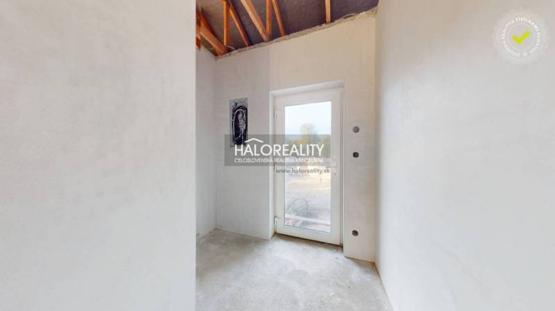 A bright room in a family house with a concrete floor and glass doors.