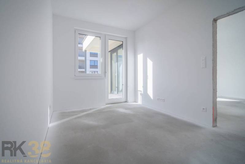 A bright room with white walls and large windows in a 3-room apartment.