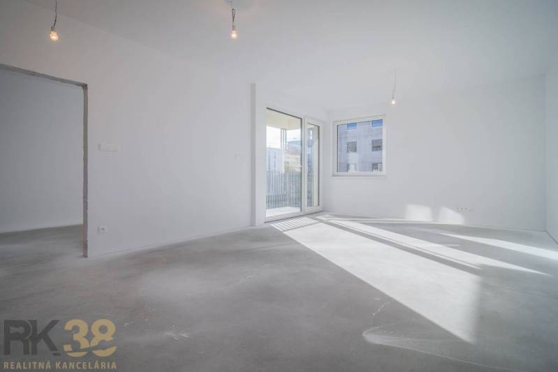 Empty bright space in a 3-room apartment with a window and balcony doors.