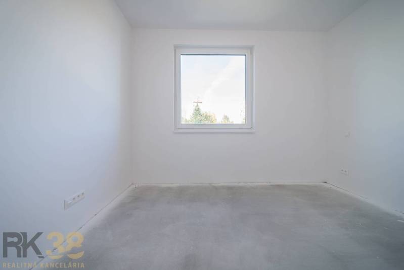 An empty room with white walls in a 3-room apartment without flooring.