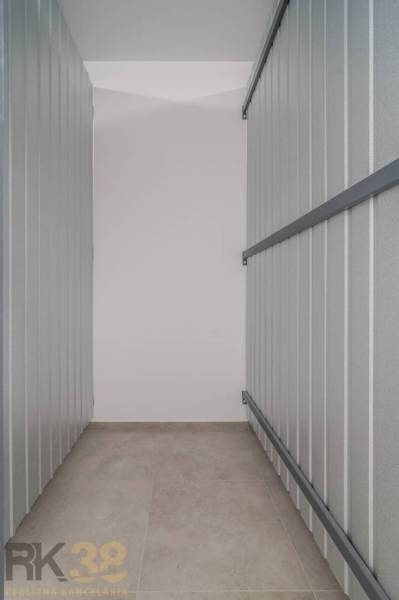 Storage space with metal walls, floor with wood decor in a 3-room apartment.