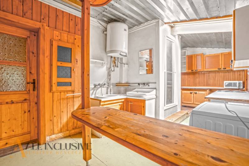 A kitchen in a family house with wooden paneling and practical equipment.