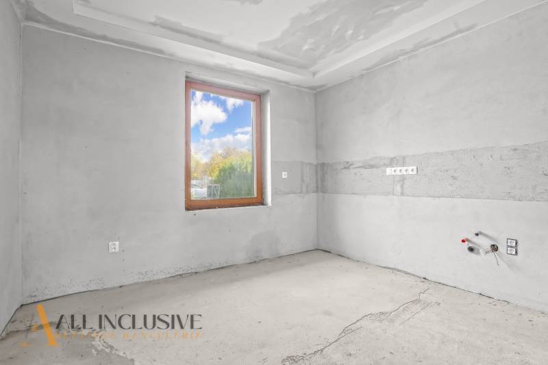 Unused room with a concrete floor and a window in a family house.