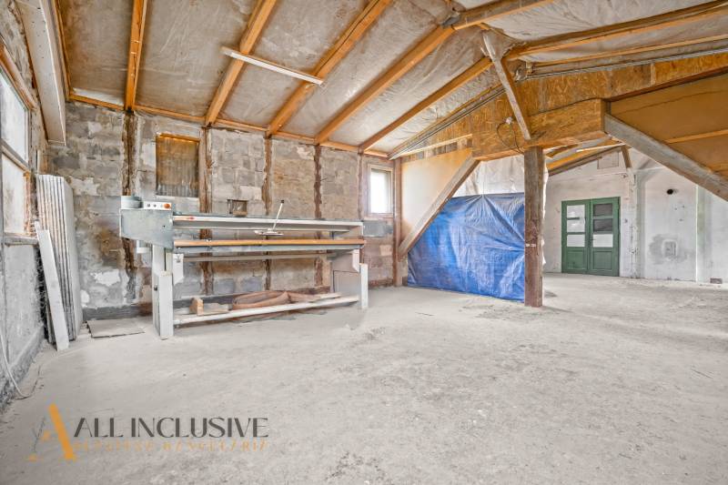A room being renovated in a family house with a sloped ceiling and building materials.