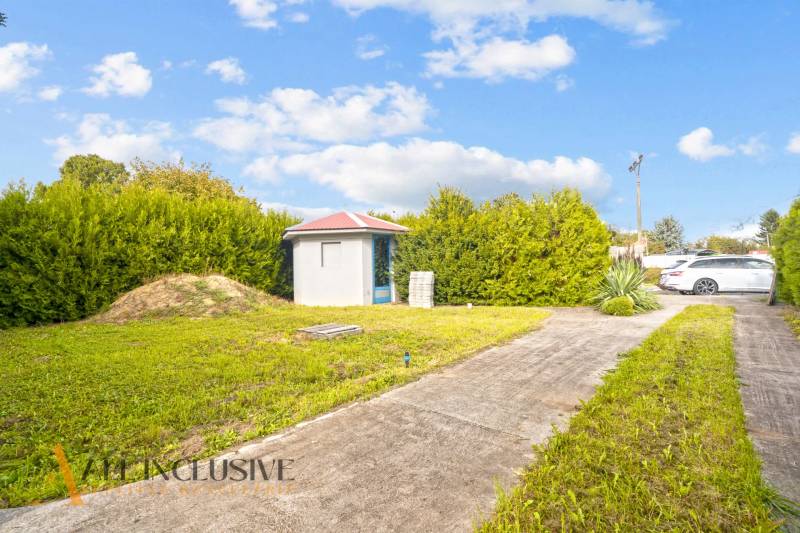 A yard at a family house in Bátorove Kosihy with a lawn and a garden shed.
