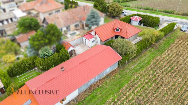Aerial view of a family house in Bátorove Kosihy with a red roof and a garden.
