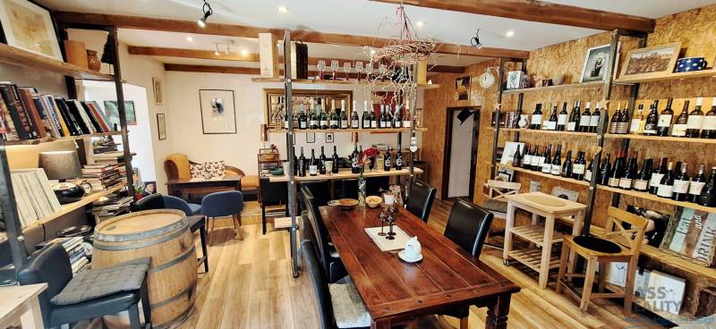 Commercial premises with a wine assortment, wooden furniture, and a floor with a wooden decor.