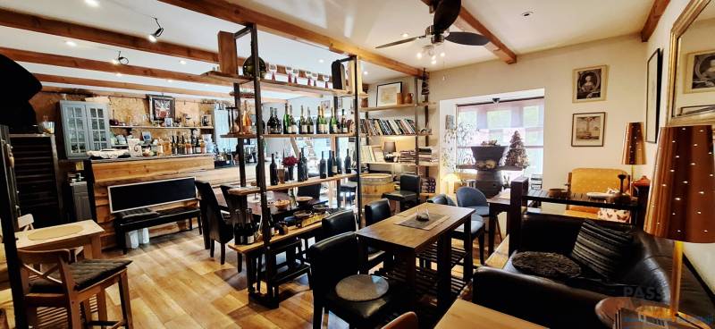 Commercial premises with equipment, wine bar, and wooden decor flooring.