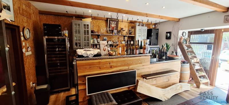 Commercial premises with a wooden bar and wines, floor with wooden decor, decorative elements.