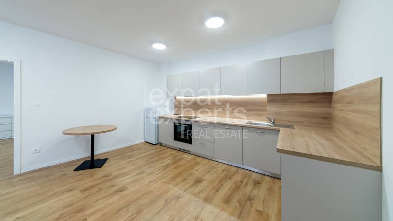 A kitchen in a 3-room apartment with a kitchen unit and a floor with a wooden decor.