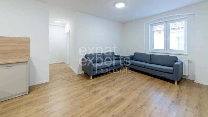 Living room with a blue sofa and a wooden decor floor in a 3-room apartment.