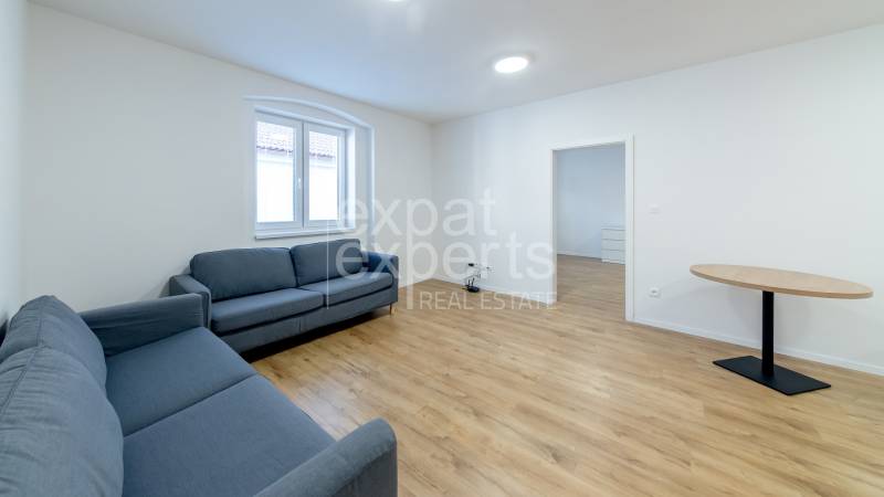 Living room with blue sofas and a table on a floor with a wood decor.