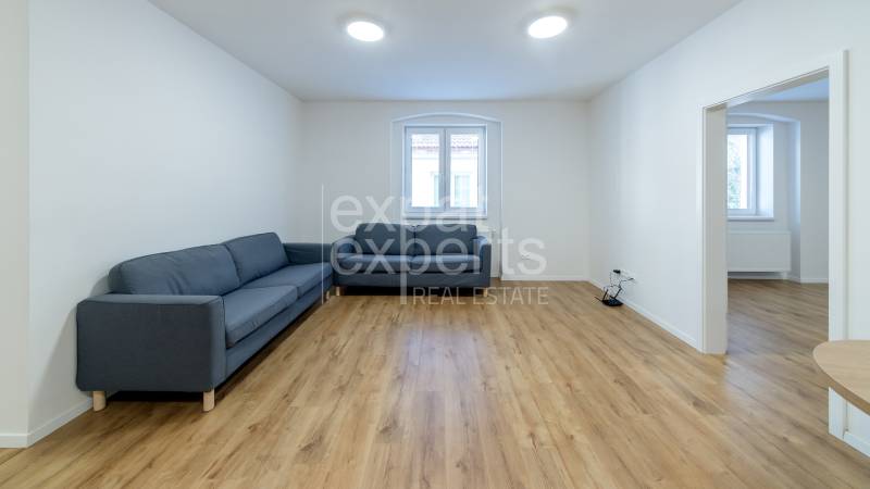 Living room in a 3-room apartment with a sofa and a wooden decor floor.