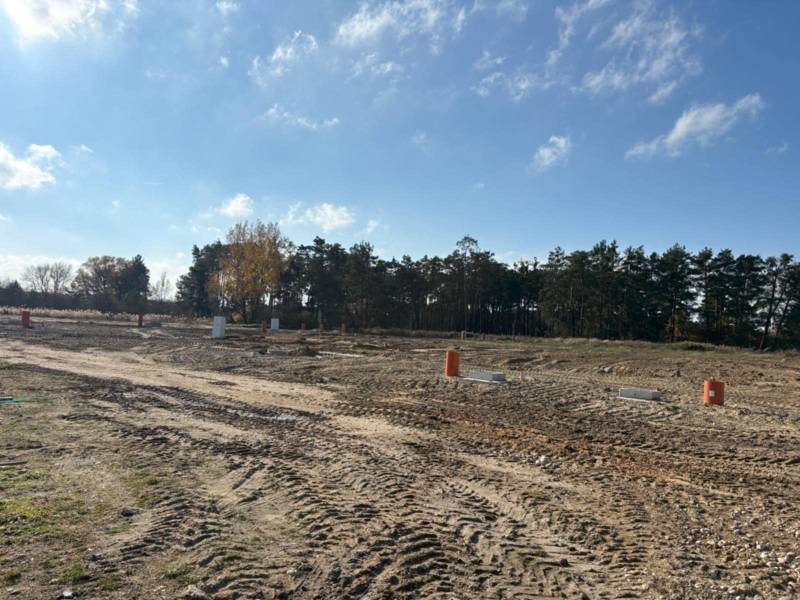 Residential plots on Pod Borovicou Street in Studienka surrounded by trees and a blue sky.