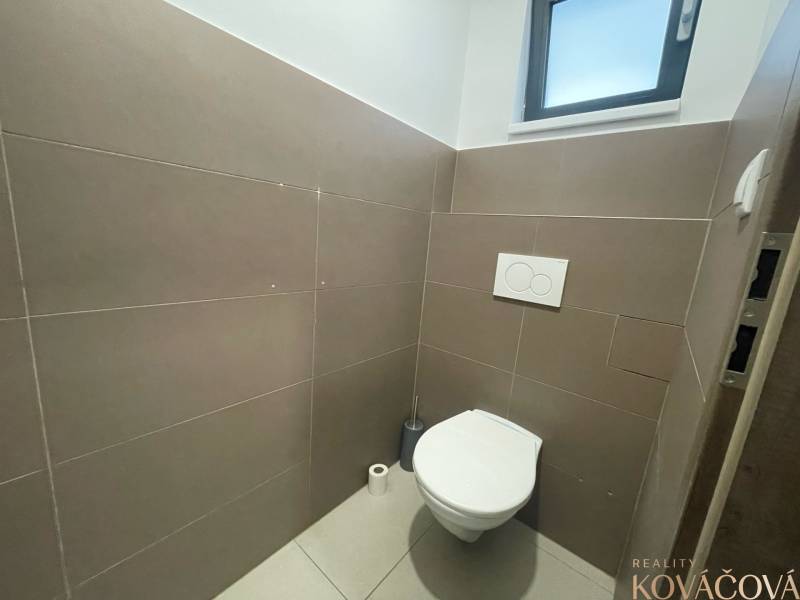 A restroom with a window and tiled floor in commercial premises.