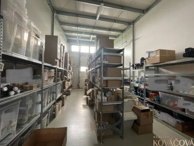 Warehouse shelves full of boxes and plastic containers in commercial premises.