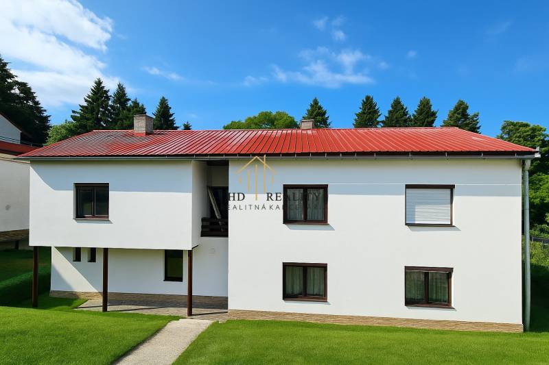 A family house in Hájik, Banská Štiavnica with a red-tinted roof and windows.