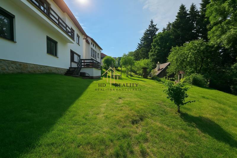 Family house in Hájik in Banská Štiavnica with a spacious green garden and trees.