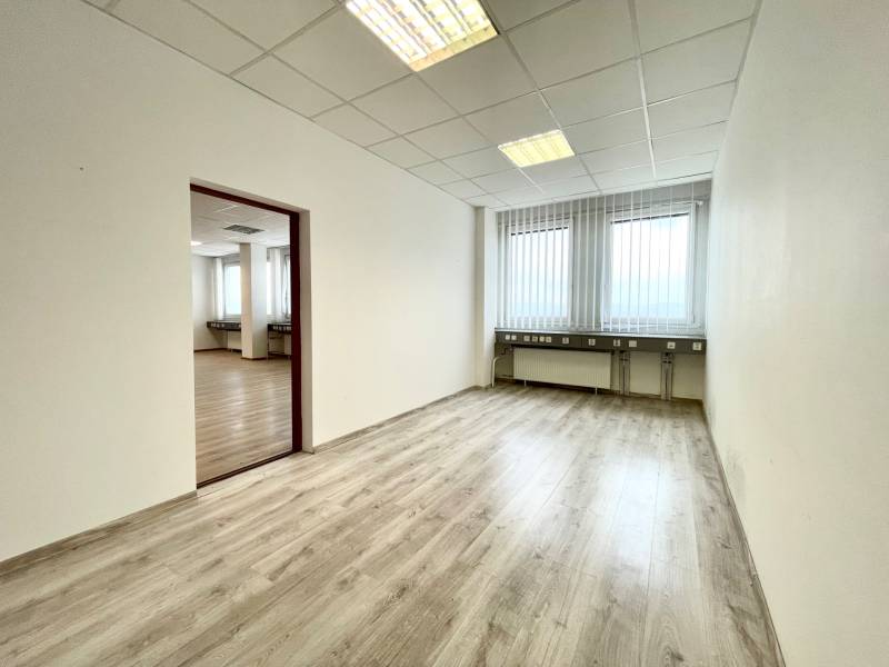 A room with white walls in offices with wood-patterned flooring.