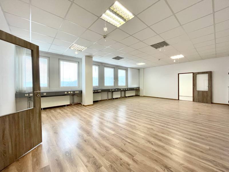 Spacious offices with wood-patterned flooring, white walls, and a coffered ceiling.