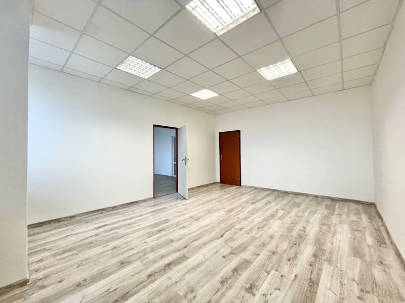 Empty office space with wood-patterned flooring and white walls.