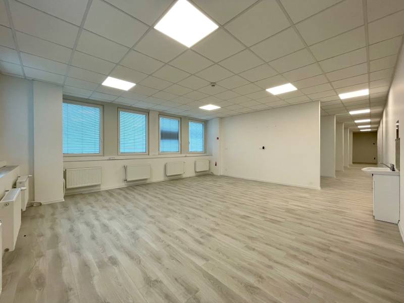 Spacious offices with wood-patterned flooring and white walls.