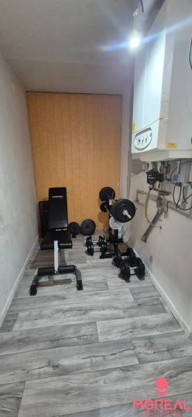 Exercise room with equipment in a 2-room apartment, floor with wooden decor.