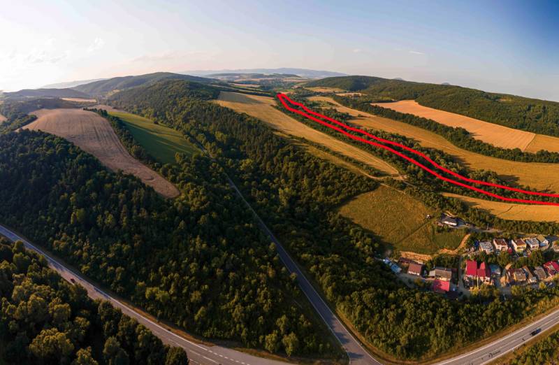 Hilly landscape with agricultural and forest lands in the Rokycany district, road along the forests.