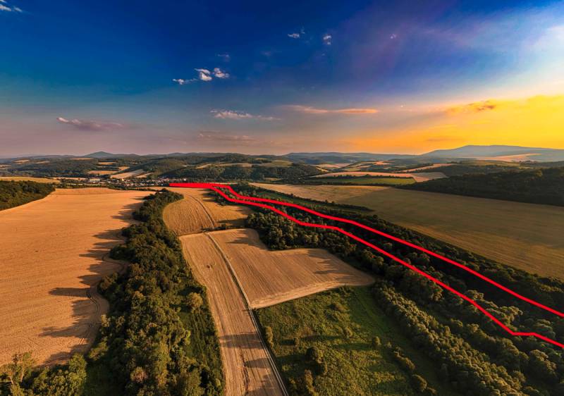 Agricultural and forest lands in Rokycany at sunset, with a visible red line.