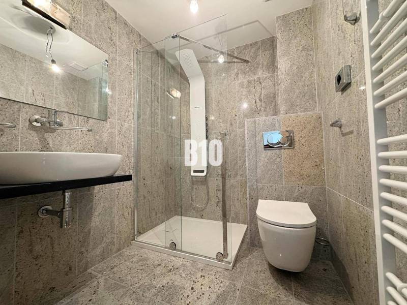 Bathroom in a 2-room apartment with a shower and a sink, tiled.