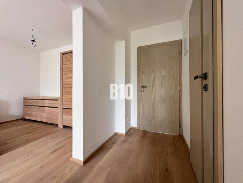 Entrance hall of a 2-room apartment with light wooden floors and interior doors.