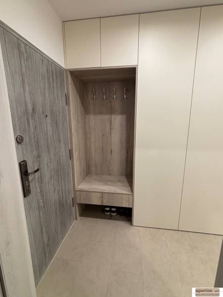 Entrance hallway with cabinets and coat racks in a 2-room apartment, wood decor on the doors.