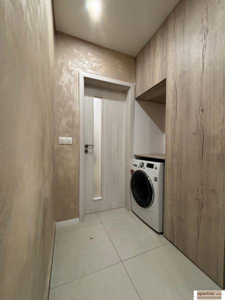 Laundry room in a 2-room apartment with tiles and a washing machine.