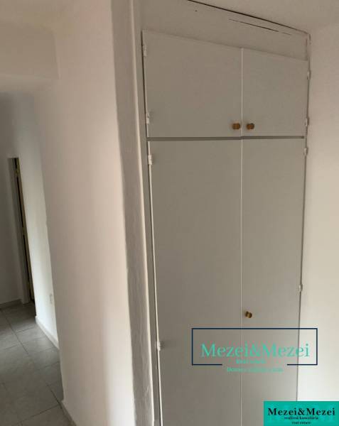 White built-in storage and tiles in a 2-room apartment.