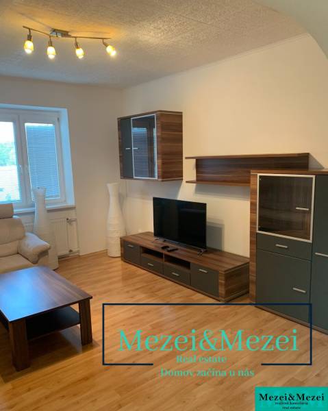 Living room with wooden floor decor, a television, and a comfortable sofa in a two-room apartment.