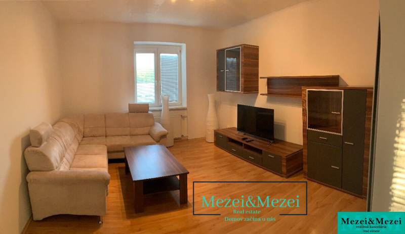 Living room with a beige sofa, wooden furniture, and a floor with a wood pattern.