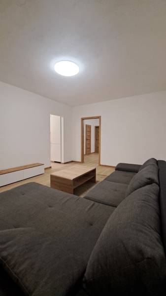 Living room with a comfortable sofa, wooden table, and floor with a wooden decor.