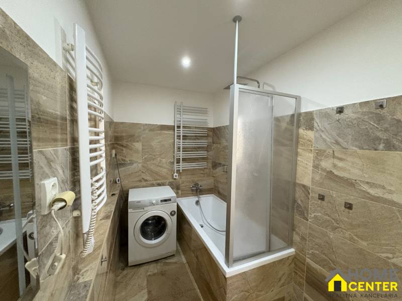 A bathroom in a 3-room apartment with a shower, bathtub, and washing machine.