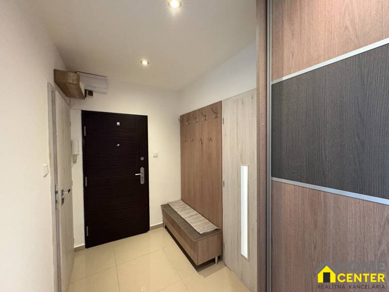 Entrance hall of a 3-room apartment with a wardrobe and a coat rack, bright environment.