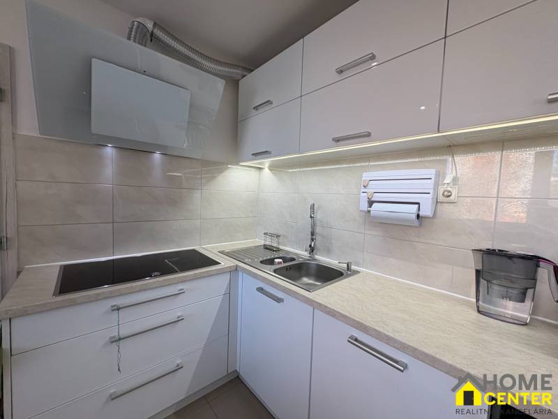 A kitchen with a built-in cooktop and sink in a 3-room apartment.
