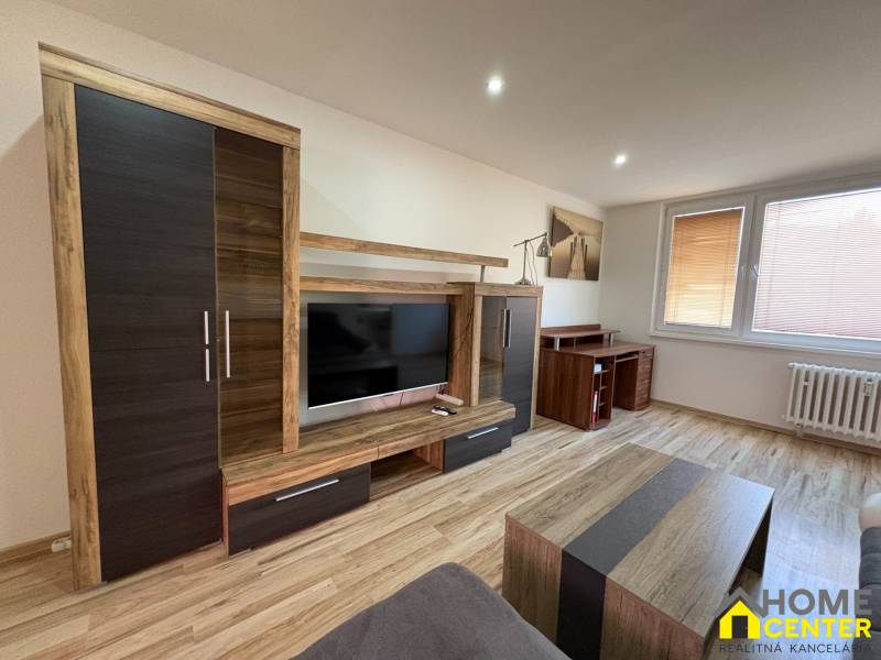 Living room in a three-room apartment with a wooden decor floor and modern furniture.