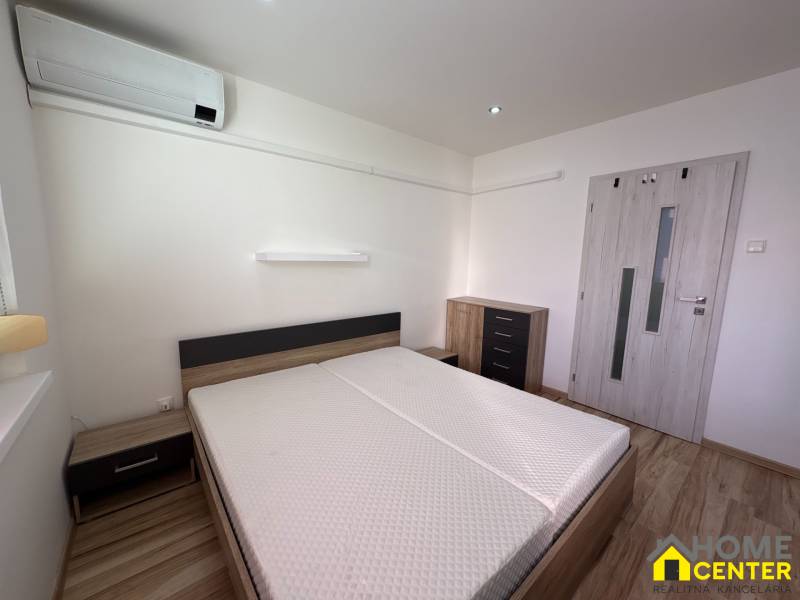 Bedroom in a 3-room apartment with air conditioning and a wooden decor floor.