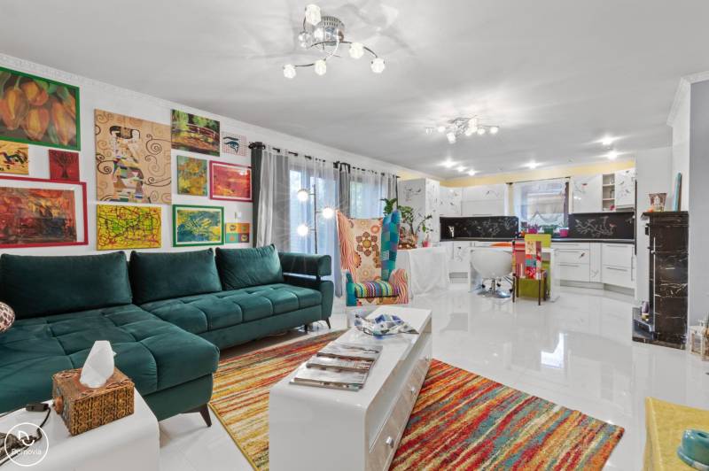 Colorful living room in a family house with a sofa, an armchair, and art on the walls.