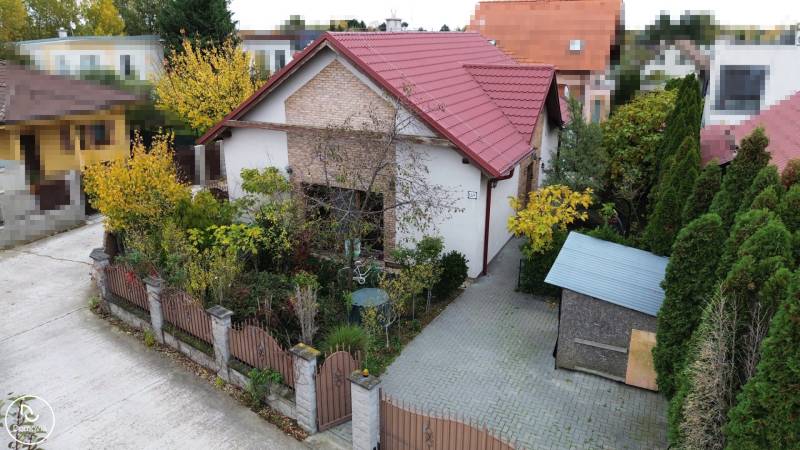 A family house on Košariská Street in Rovinka with a red roof and a garden full of greenery.