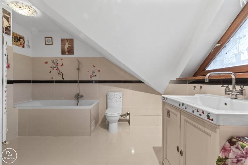 A bathroom in a family house with a bathtub, toilet, and decorative stickers on the walls.