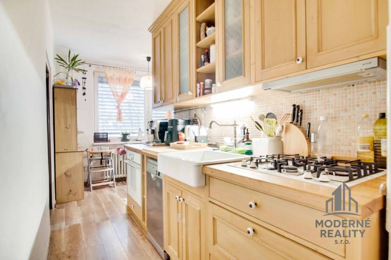 A kitchen in a 3-room apartment with a wooden decor and a spacious work surface.