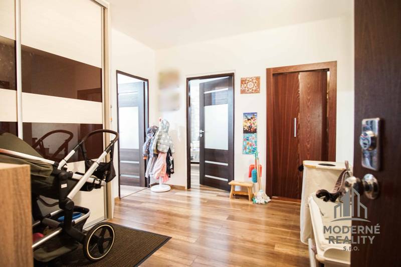 Entrance hall with wood-patterned flooring in a 3-room apartment.