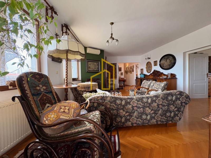 Living room in a 5 or more room apartment with wood-patterned flooring and vintage furniture.