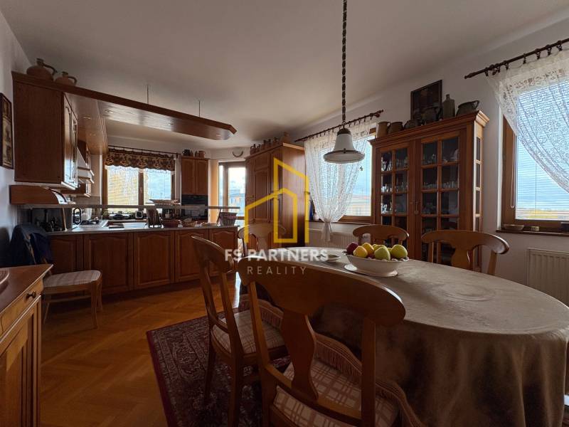 A kitchen in a 5 or more room apartment with a dining table and a wooden decor floor.